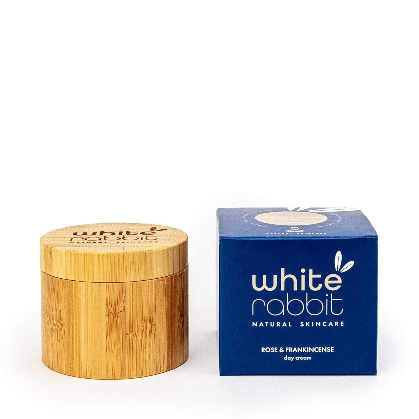 Wooden jar and blue box of White Rabbit Natural Skincare on a white background