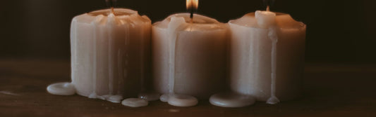 Three lit white candles in a row