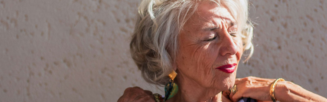Woman with natural white hair wearing a dark blue top