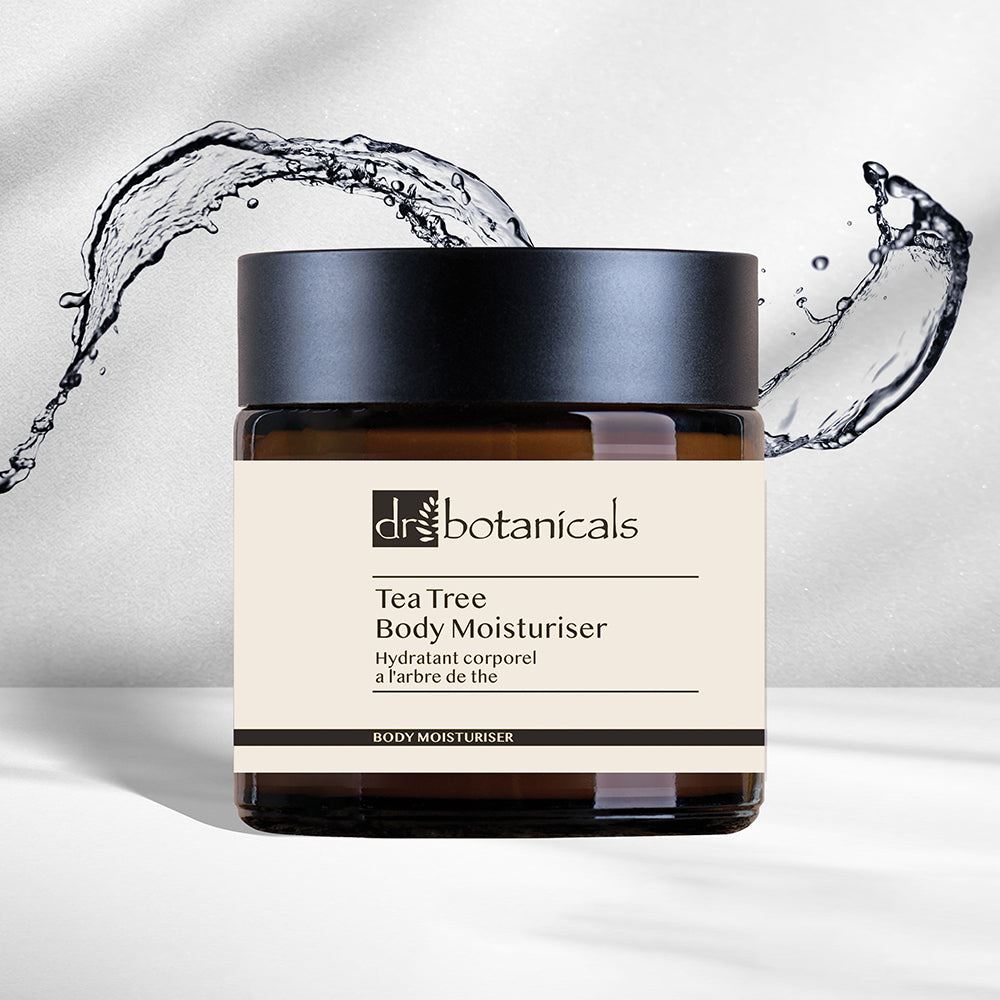 Jar of Dr. Botanicals Tea Tree Body Moisturizer with water splashes on a light background