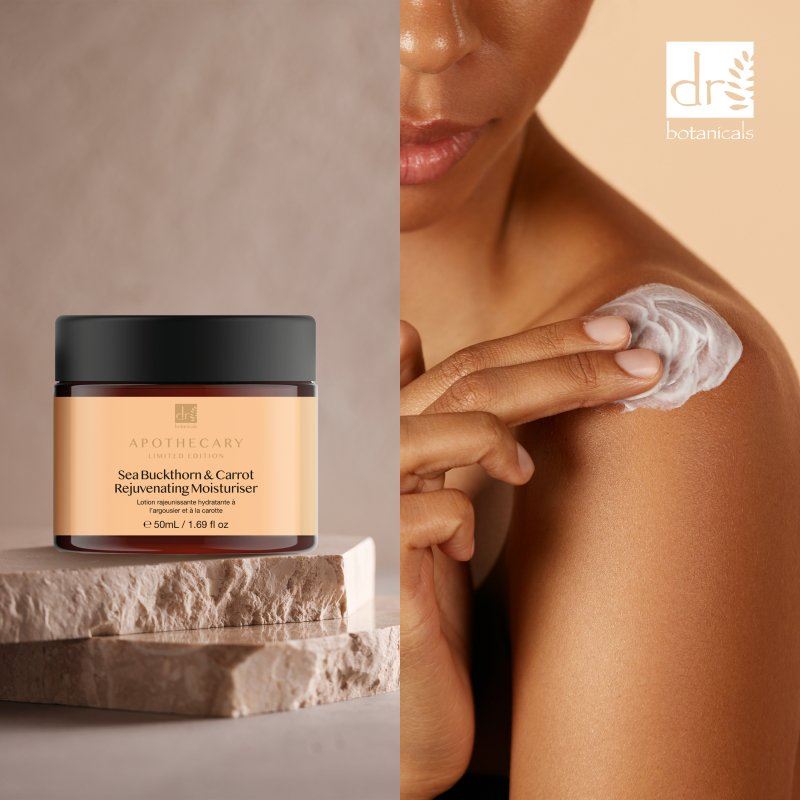 Aphthecary Sea Buckthorn & Carrot Rejuvenating Moisturizer jar with a person applying cream to their shoulder.