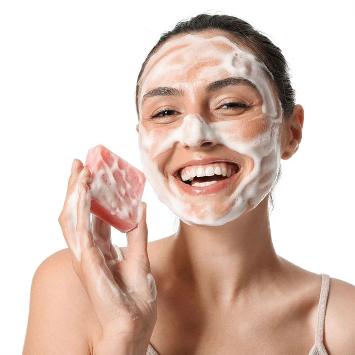 Woman applying Dr Botanicals La Rose Française Facial Cleansing Bar on a white background