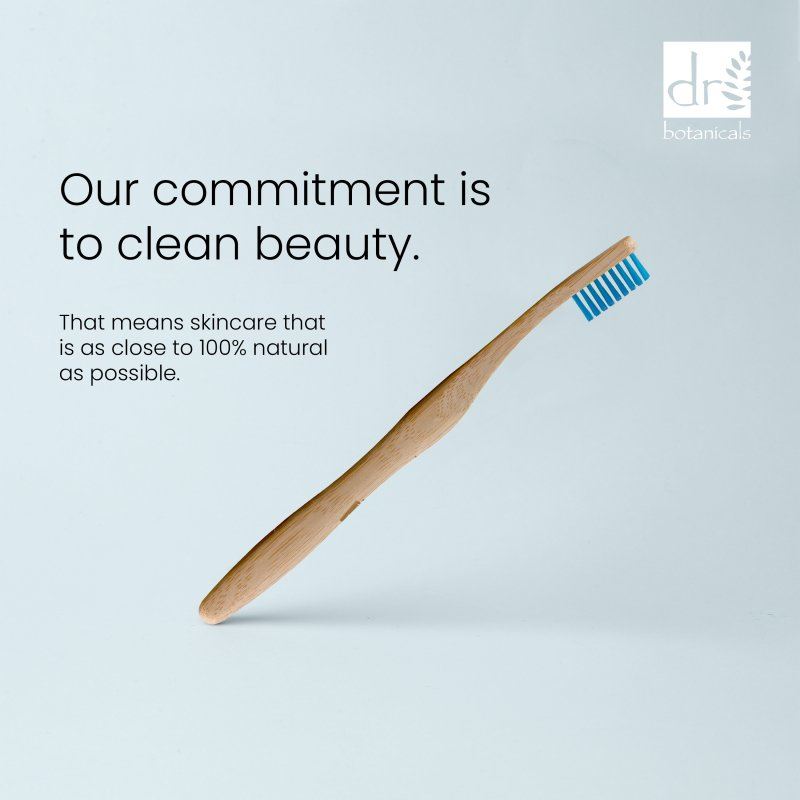 Bamboo toothbrush with blue bristles on a light gray background, featuring a brand logo.
