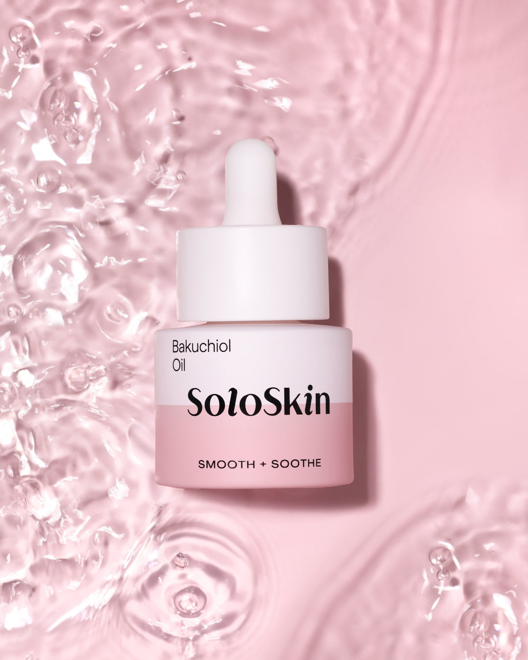 SoloSkin Bakuchiol Oil bottle on a pink background with water droplets