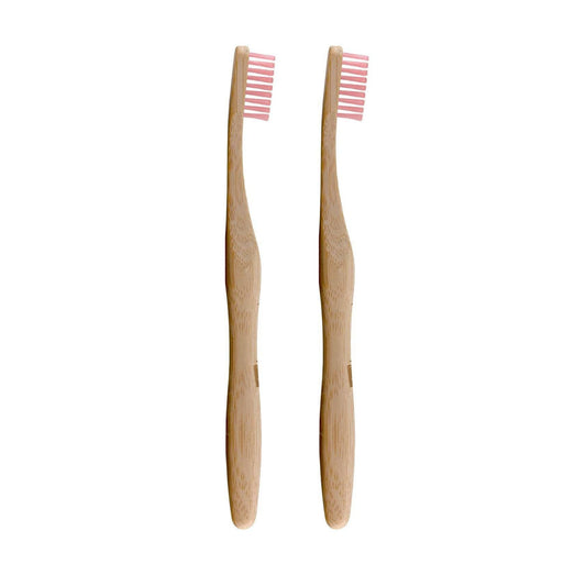 Two bamboo toothbrushes with pink bristles on a white background