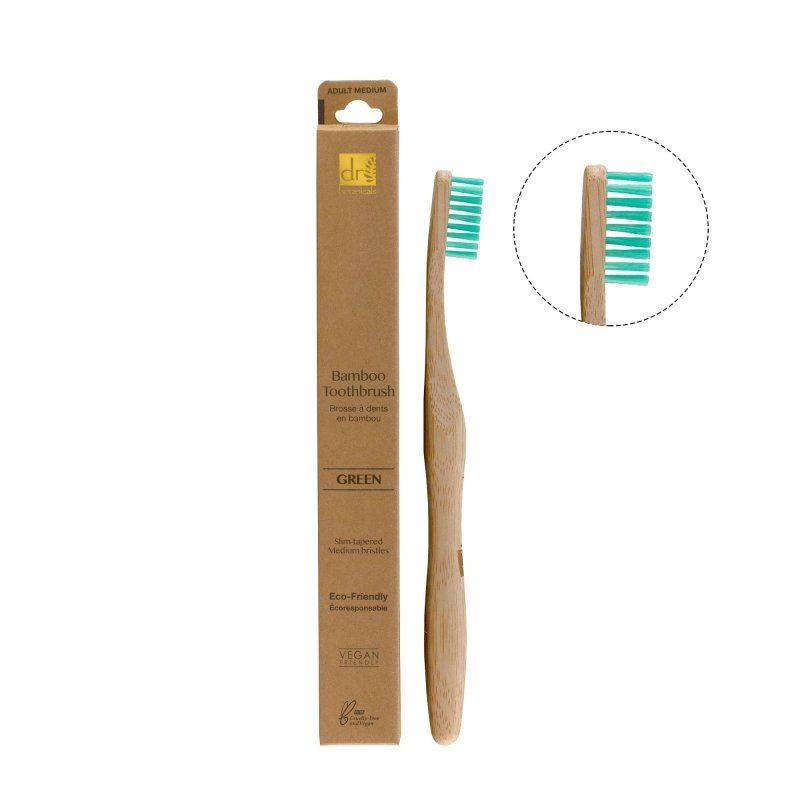 Bamboo toothbrush with green bristles and packaging on a white background