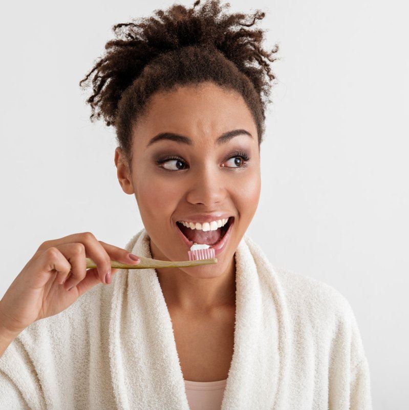 Woman brushing her teeth with a white background