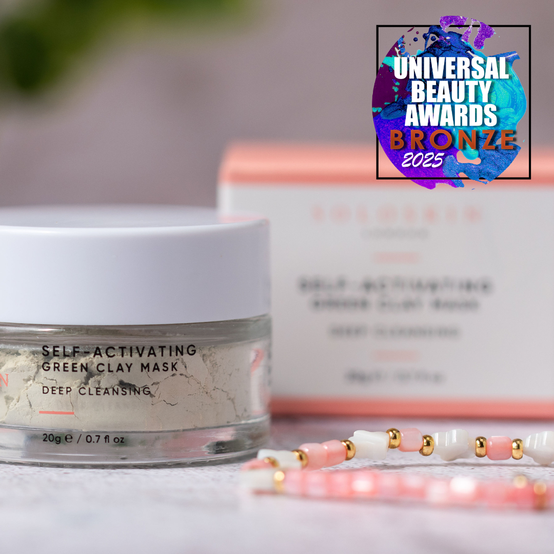 Self-activating green clay mask with packaging and a bronze award badge on a blurred background