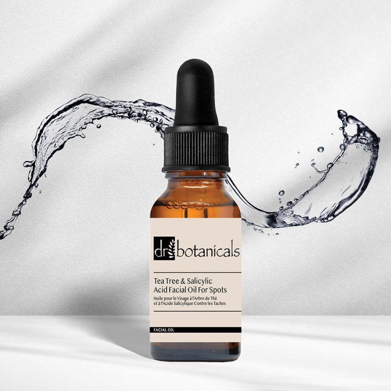 Dr. Botanicals Tea Tree & Salicylic Acid Facial Oil with water splash on a light background