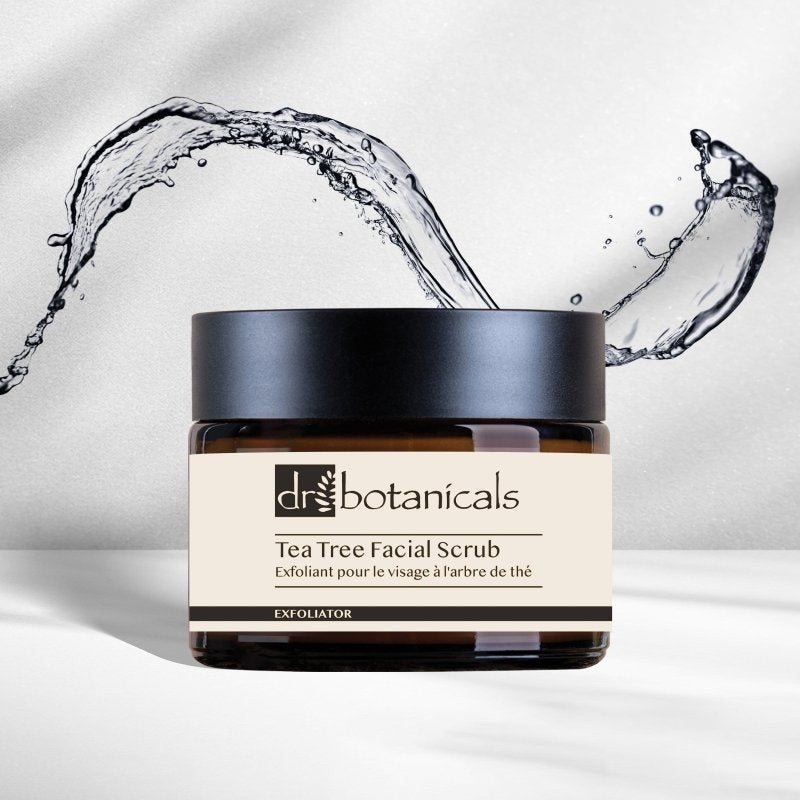 Dr. Botanicals Tea Tree Facial Scrub jar with water splashes on a light background
