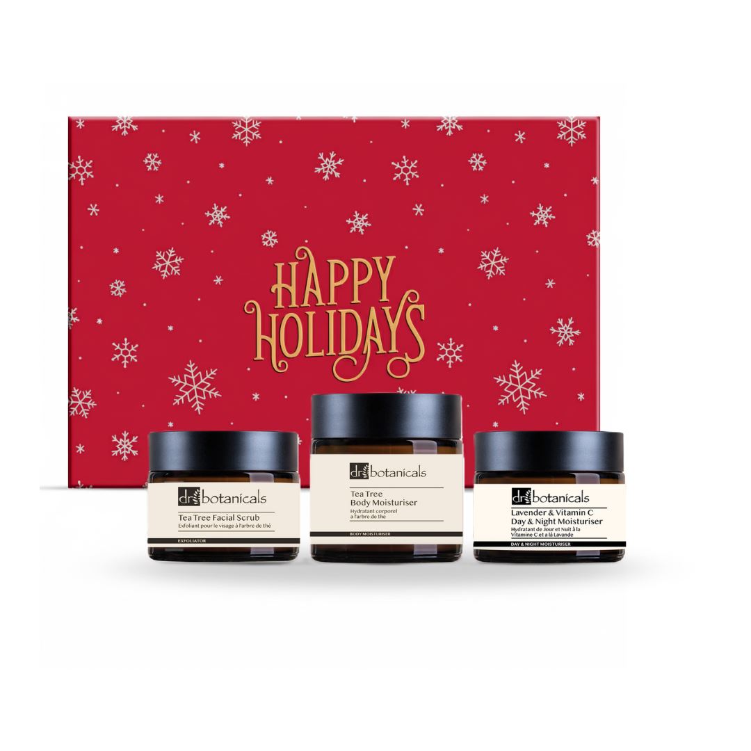 Three skincare jars with a 'Happy Holidays' gift box in the background