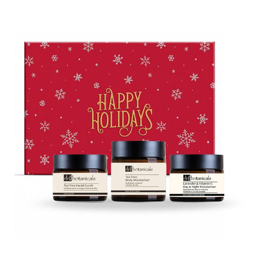 Three skincare jars with a 'Happy Holidays' gift box in the background