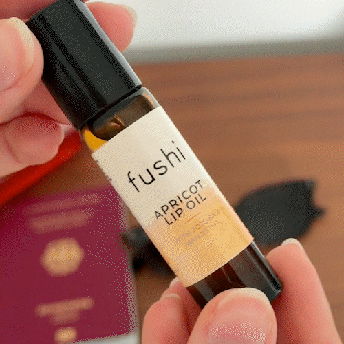 Fushi Apricot Lip Oil 10ml beingv used by a woman