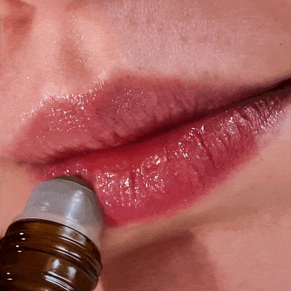 Fushi Cherry Lip Oil 10ml being used by a woman.