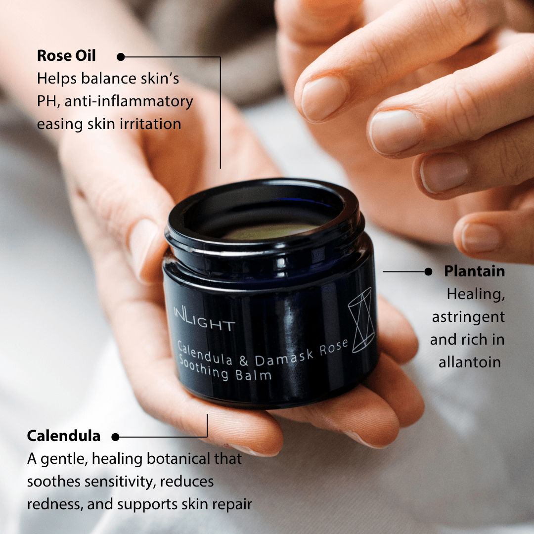 Black jar of Inlight Beauty Calendula & Damask Rose Soothing Balm 45ml held by hands with product details on a blurred background