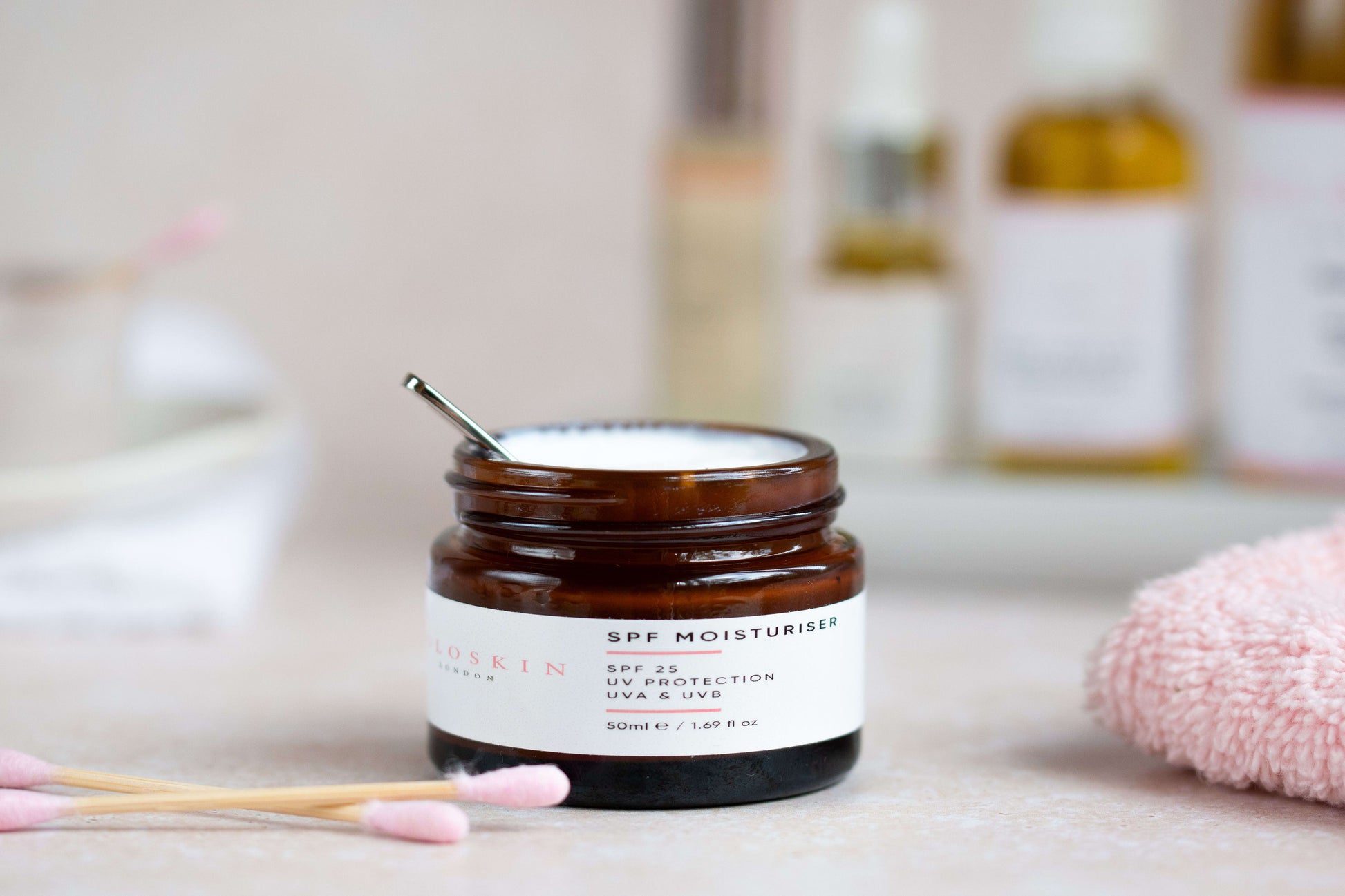 Jar of skincare product with a brush on a bathroom counter