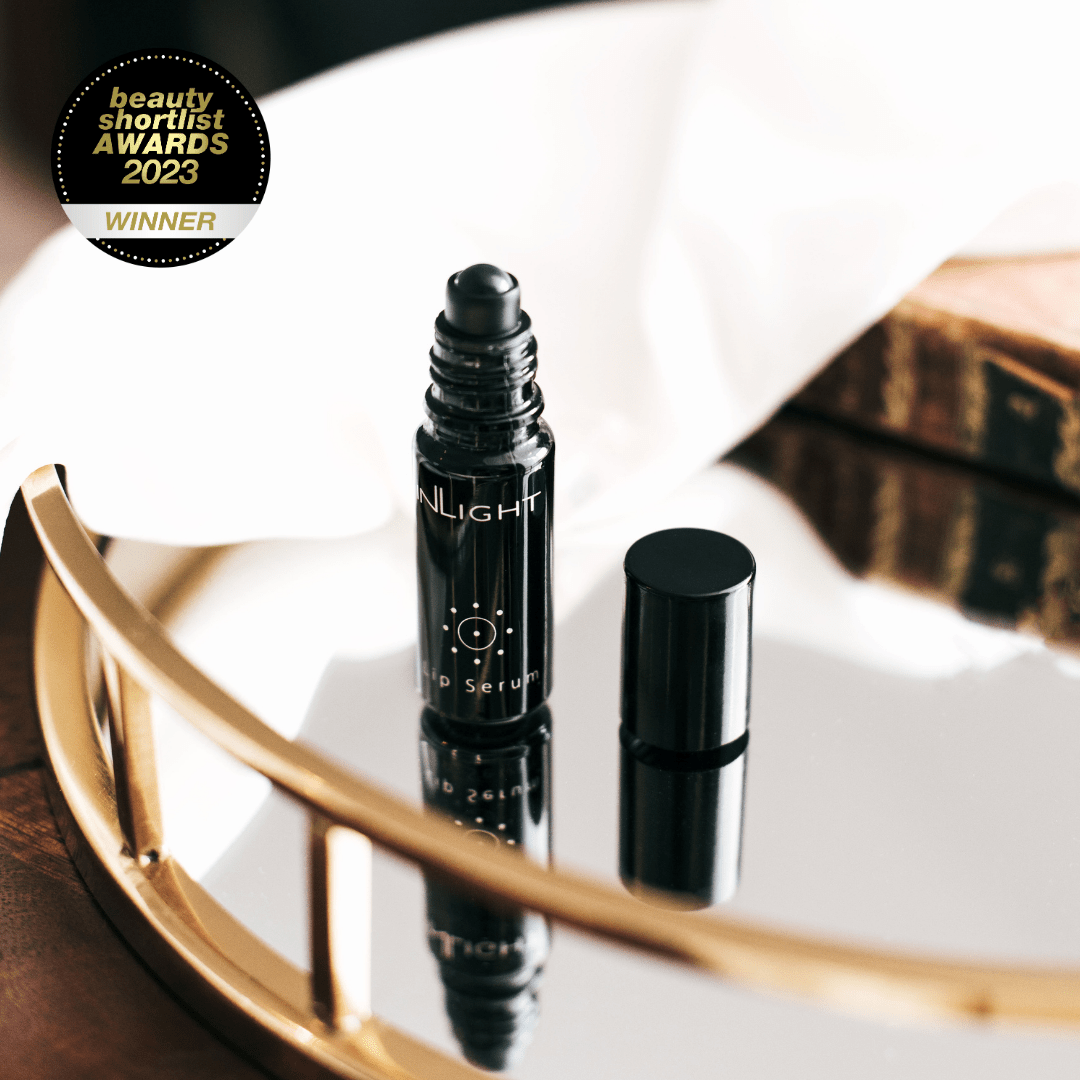 Black rollerball bottle labeled 'INLIGHT' on a reflective surface with 'Beauty Shortlist Awards 2023 Winner' badge.