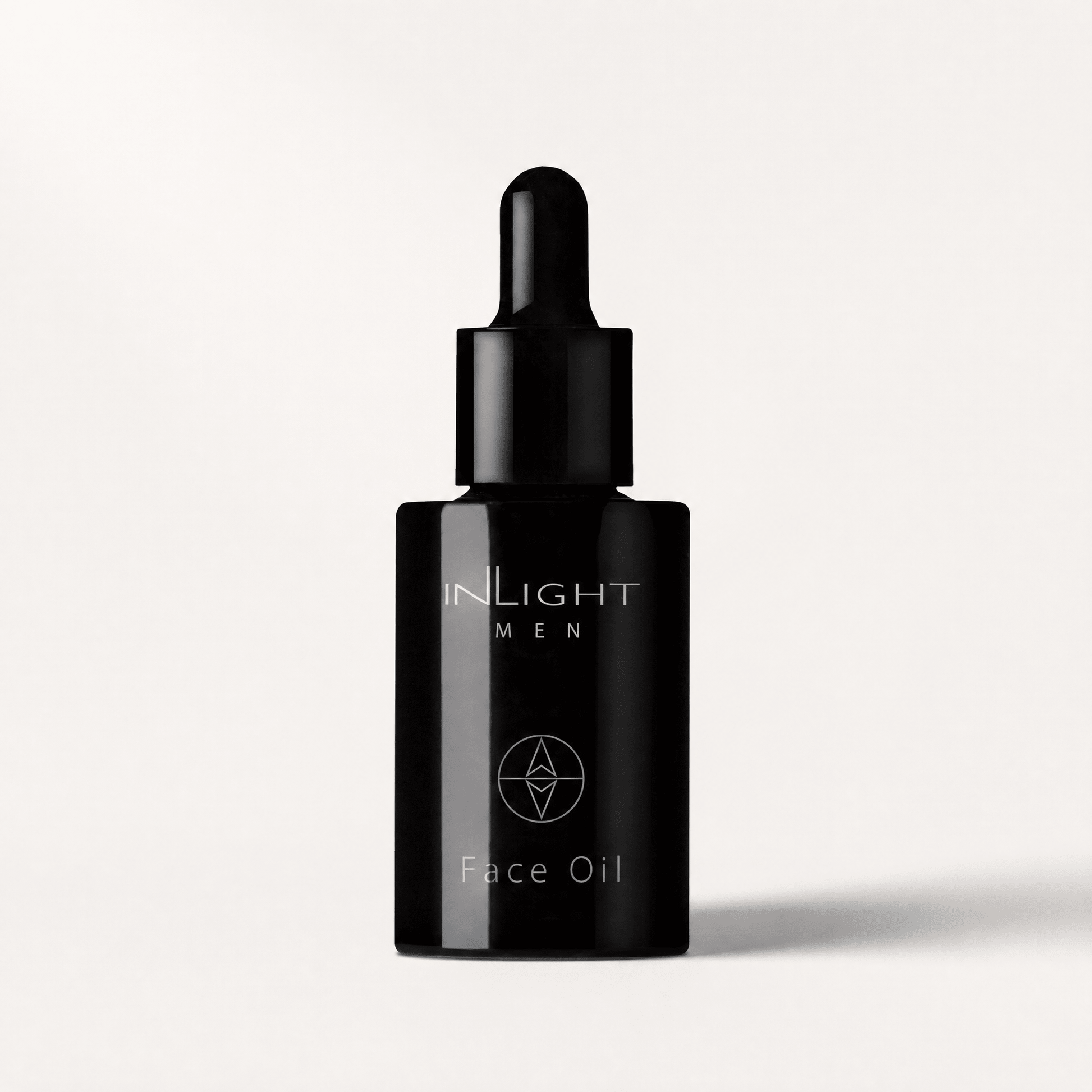 Black face oil dropper bottle with Inlight Beauty Face Oil for Men 30ml branding on a light grey background