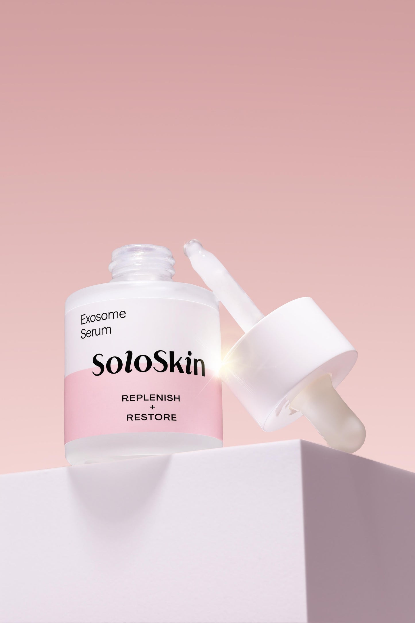 SoloSkin Exosome Serum bottle with dropper on a pink background