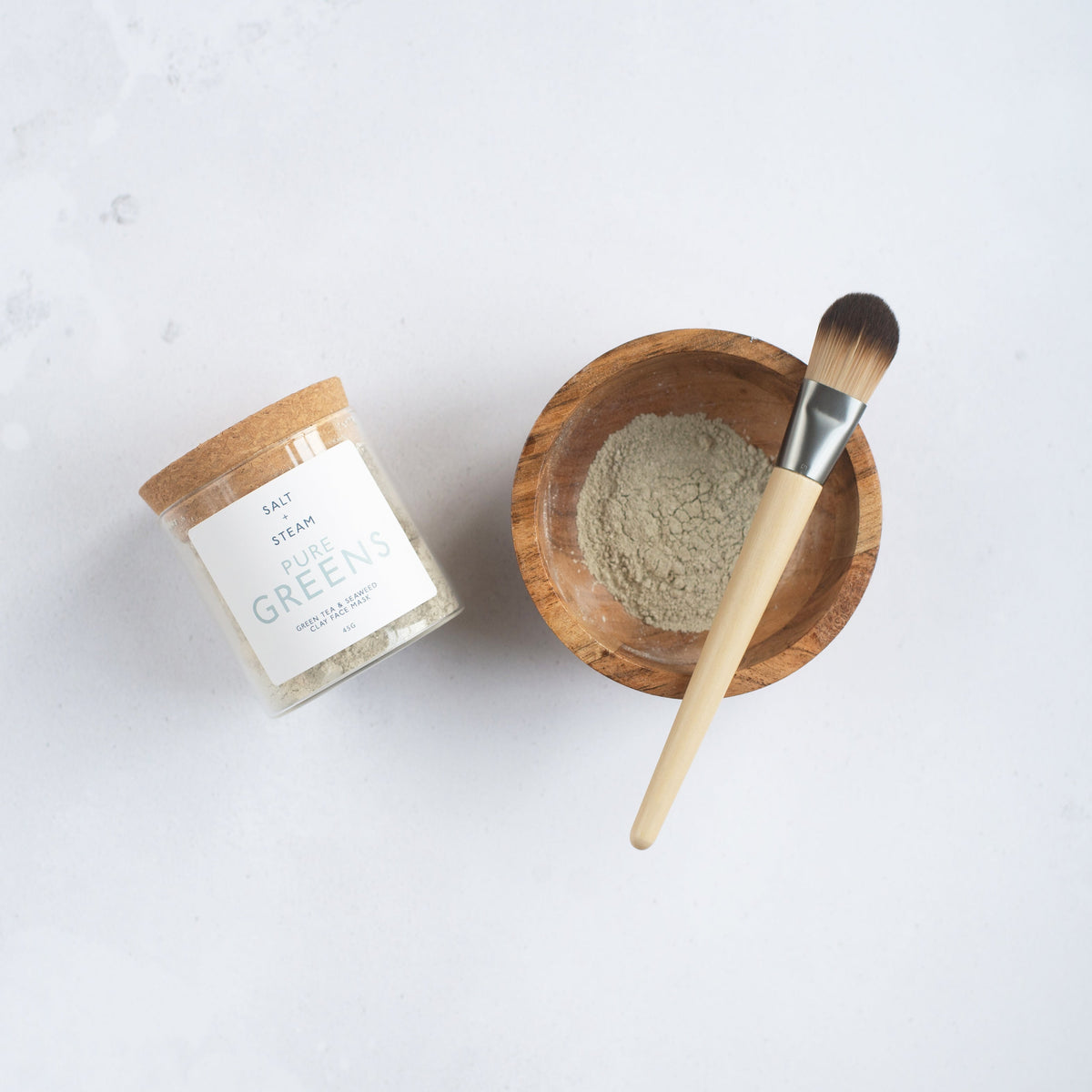 Salt + Steam Pure Greens clay face mask being applied