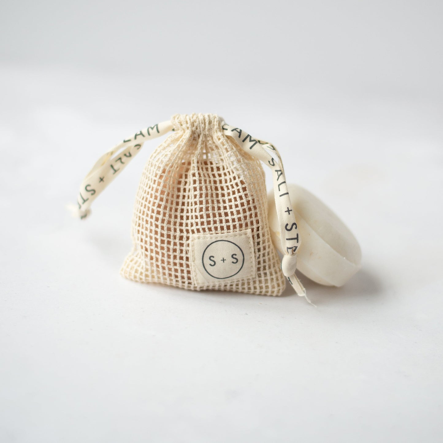 Salt + Steam storage bag holding a shampoo bar