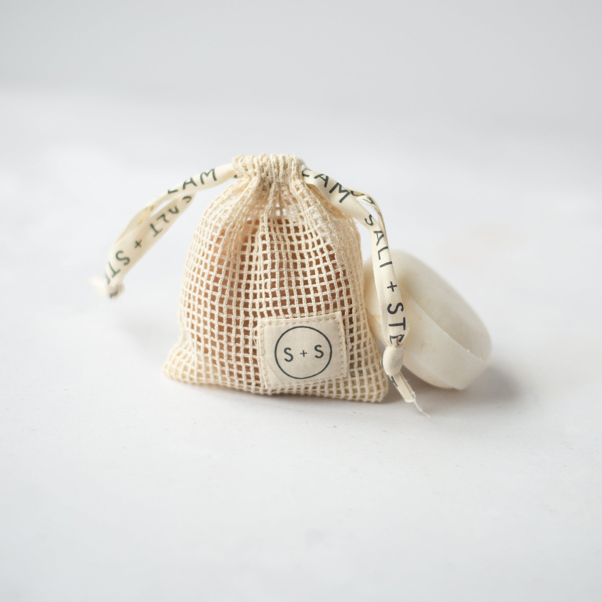 Salt + Steam storage bag holding a shampoo bar