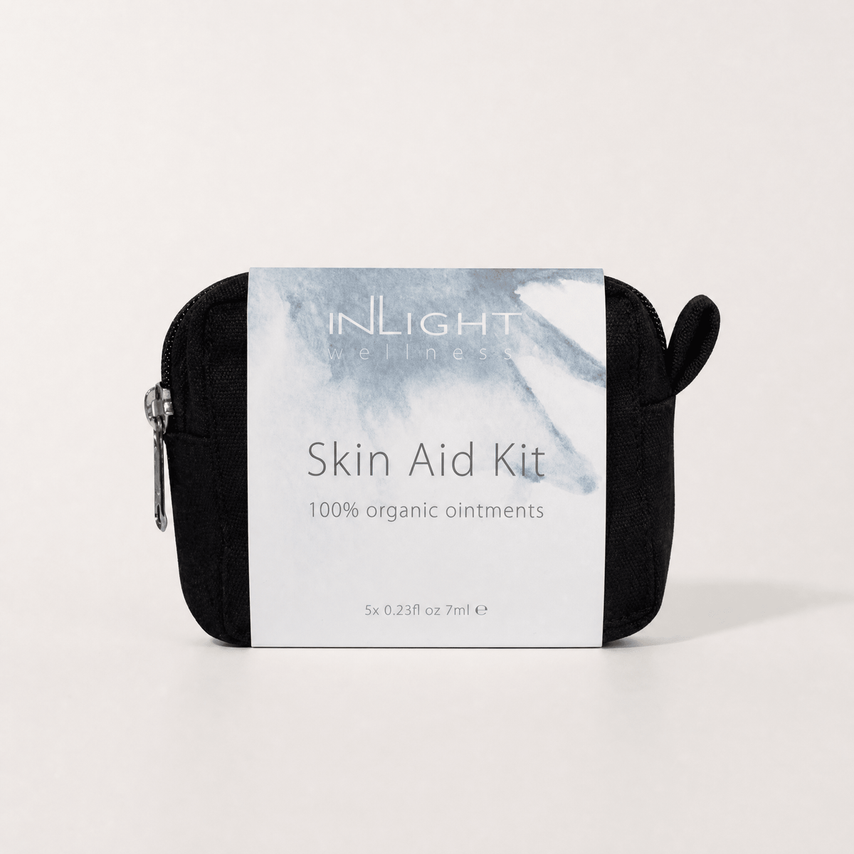 A black zippered skin aid pouch with a white and blue watercolour label reading 'INLIGHT Skincare Skin Aid Kit 100% organic ointments' on a light grey background.