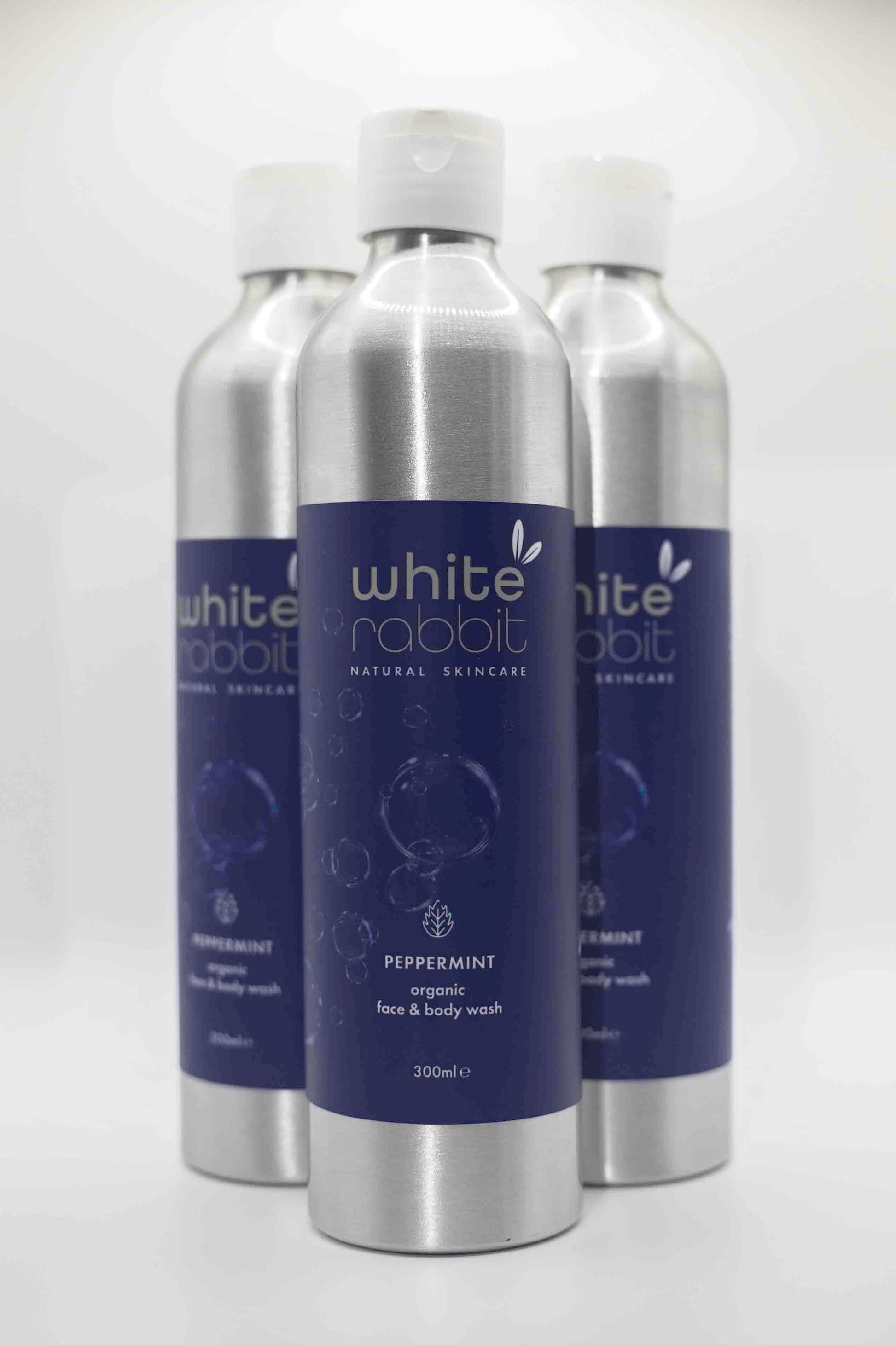 Three bottles of White Rabbit natural skincare products on a white background