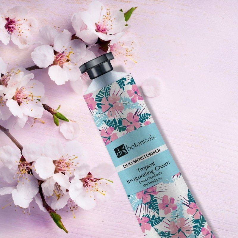 skinChemists Tropical Invigorating Cream with floral design on a pink background with cherry blossoms