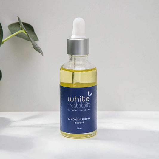 Bottle of White Rabbit skincare oil with a dropper on a white surface.