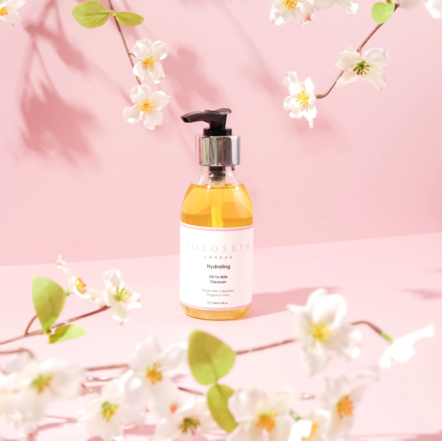Skincare bottle with pump on a pink background with floral elements