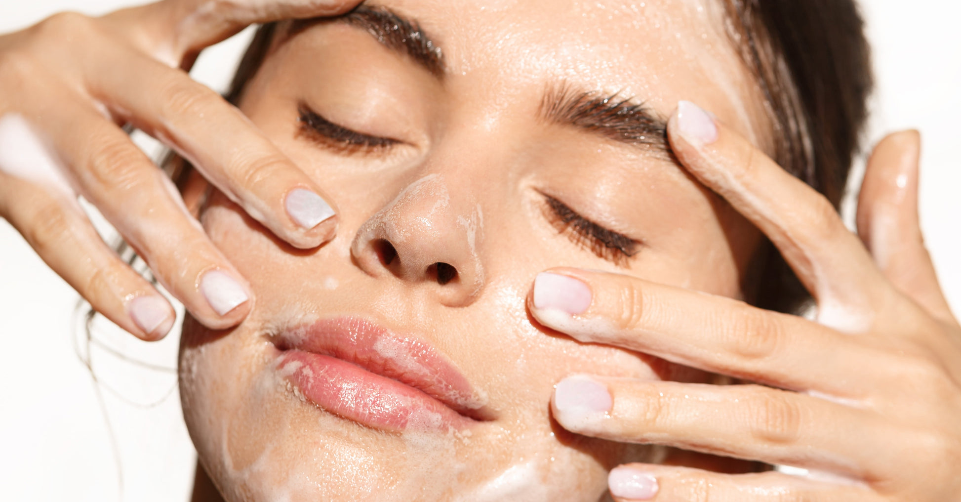 Woman with hands on face, possibly after a skincare routine