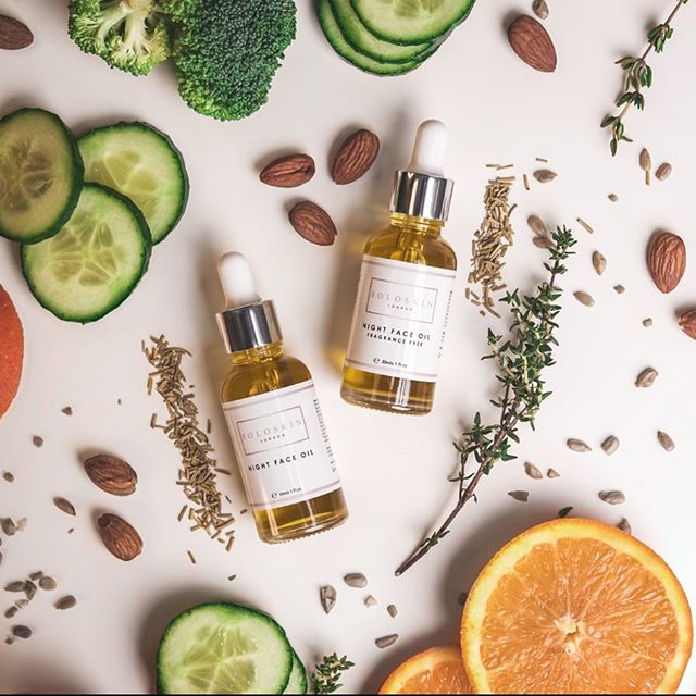 Two bottles of night face oil with natural ingredients on a white background