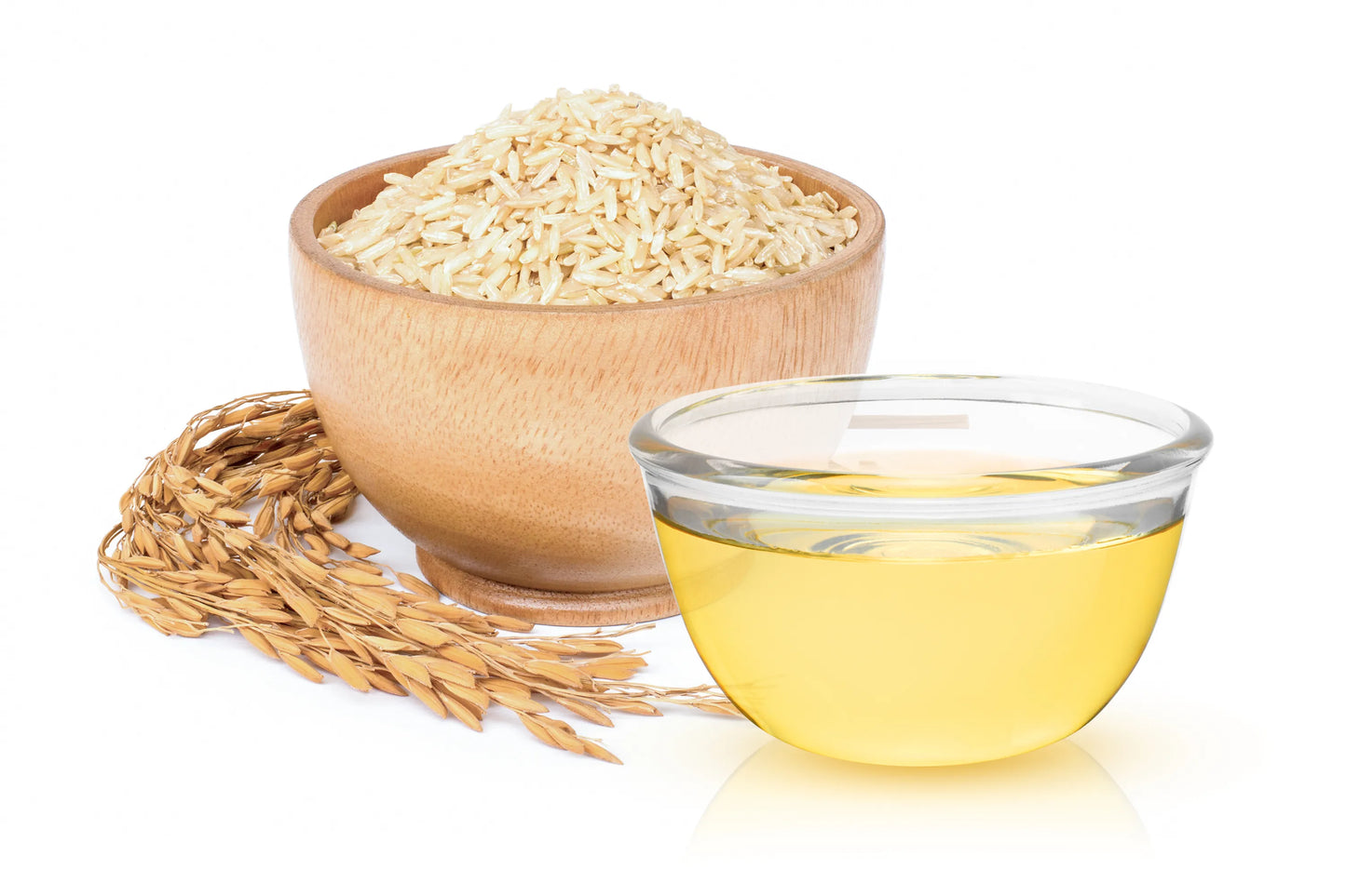 Wooden bowl of rice and glass container of rice oil on a white background