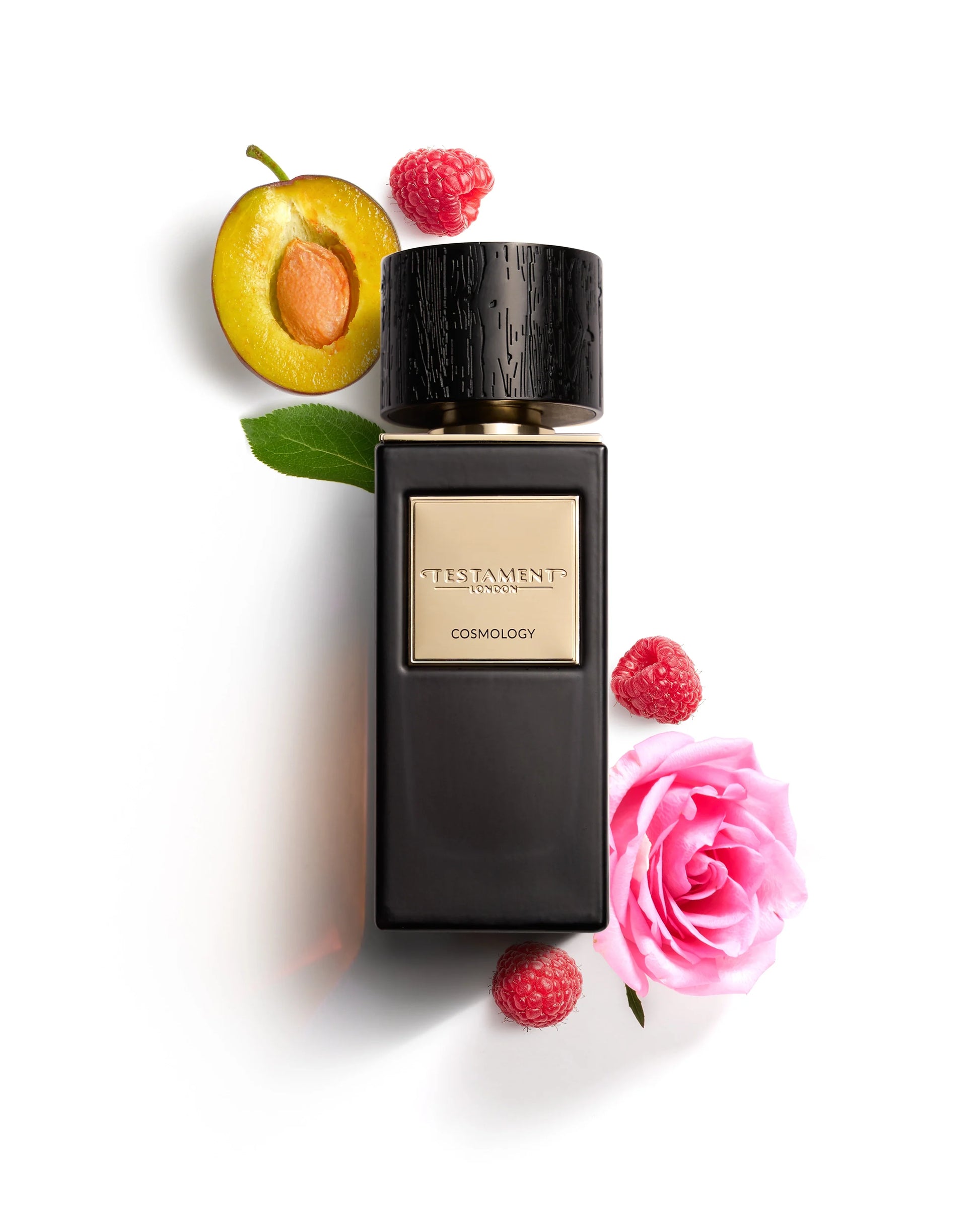 Black perfume bottle with raspberries, a peach, and a pink rose on a white background