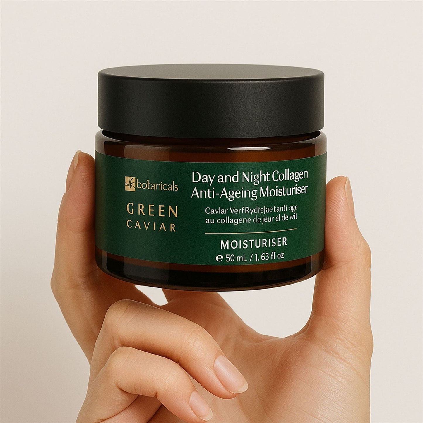 Hand holding a jar of 'Green Caviar' anti-ageing moisturizer with a beige background