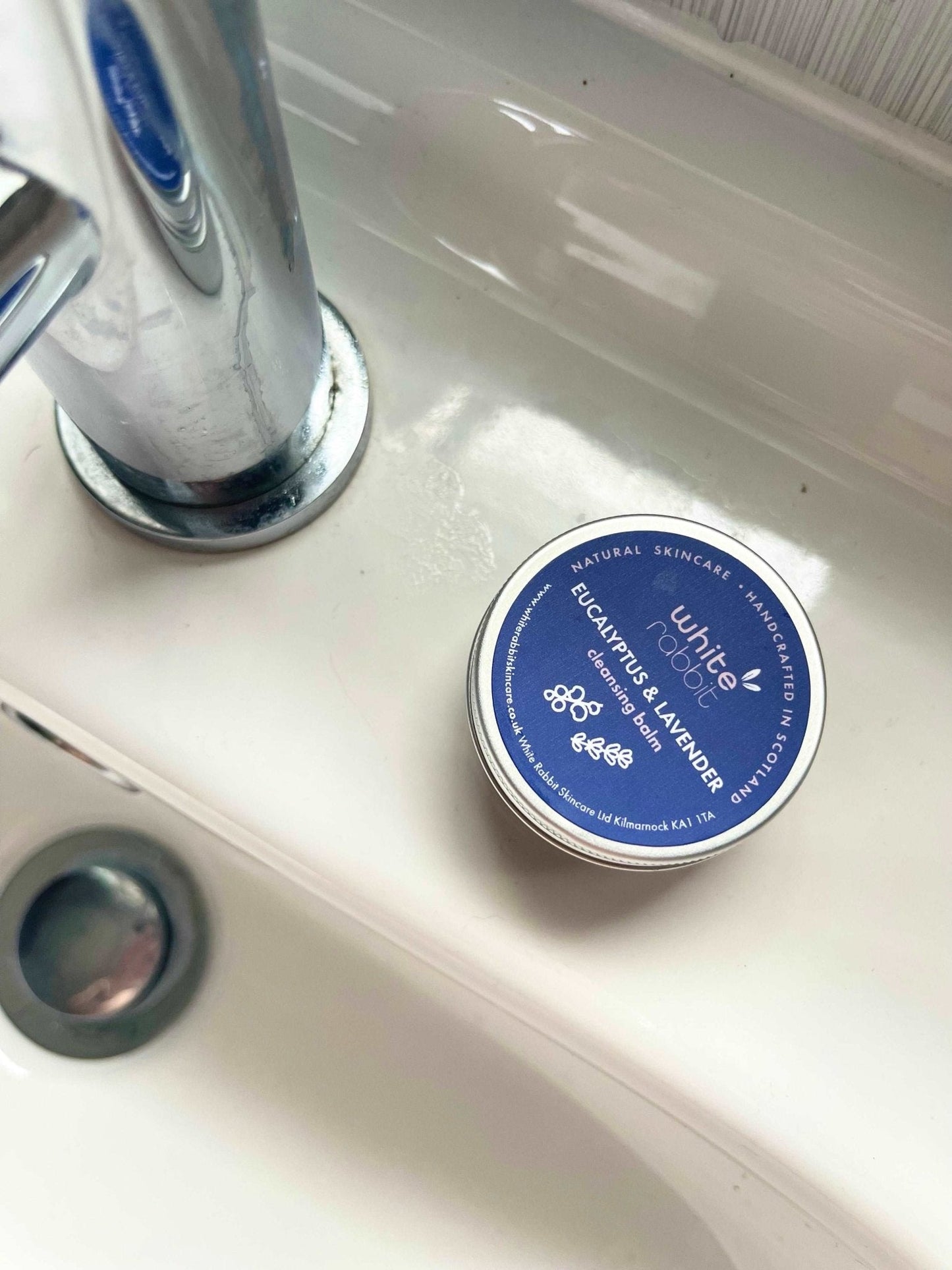 Tin of White Flower Balsamic Eucalyptus & Lavender on a sink