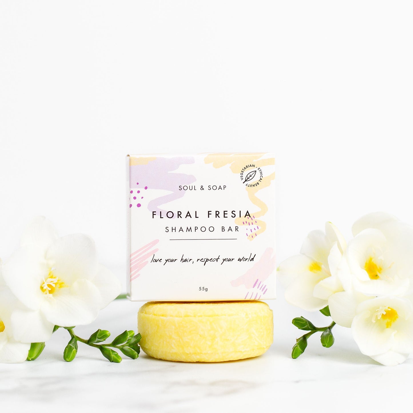 Floral Fresia shampoo bar with packaging on a white background