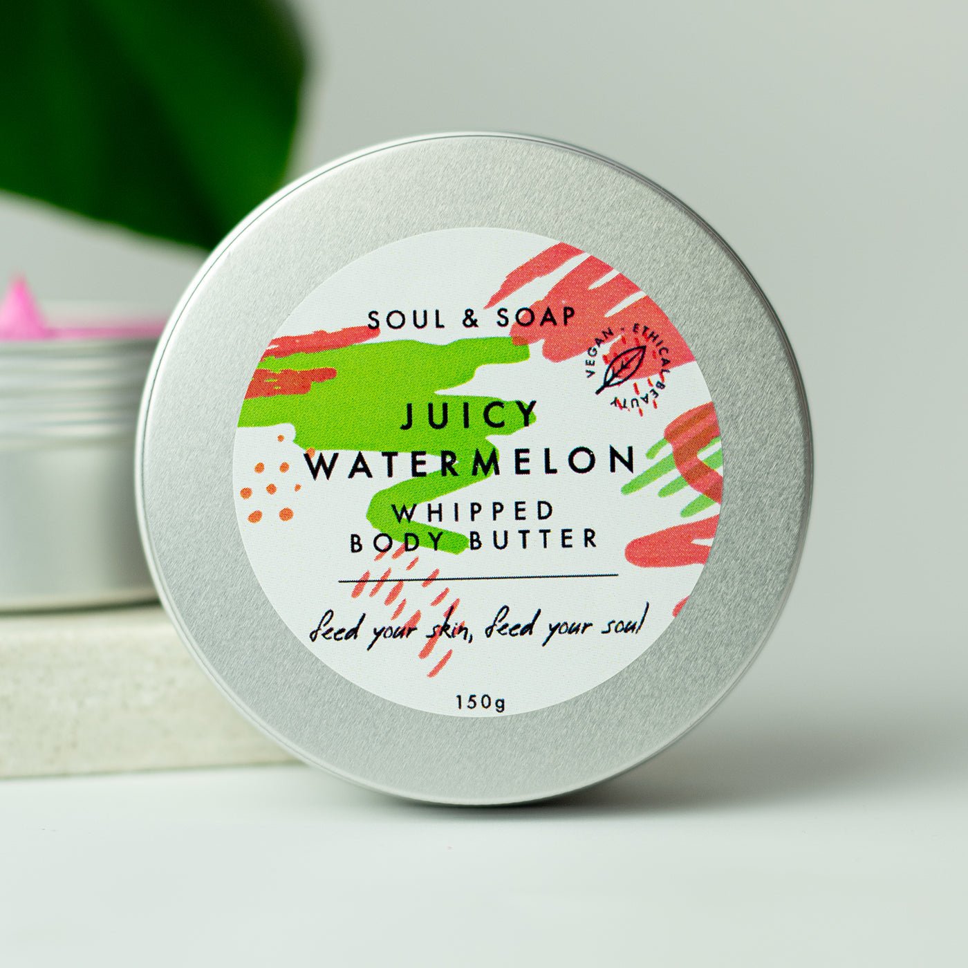 Tin of 'Juicy Watermelon' whipped body butter with colorful label on a white background