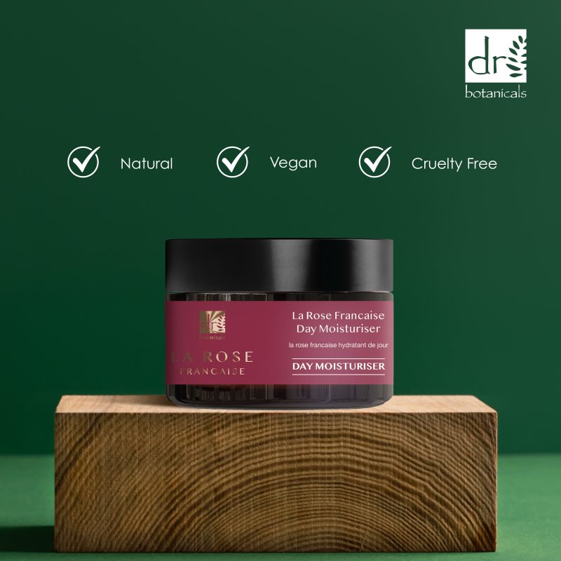 Day moisturizer jar on a wooden block with green background and Dr Botanicals logo.