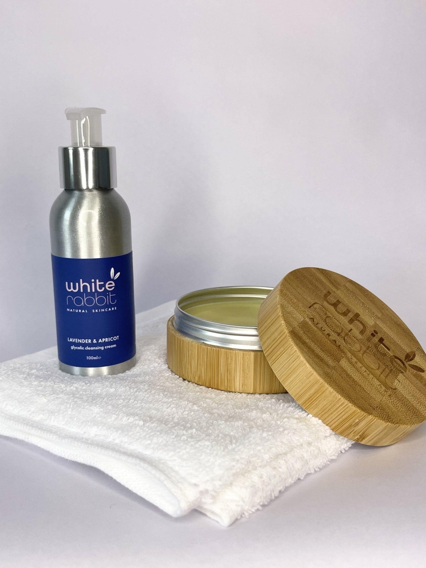 Silver bottle and wooden container with 'White Rabbit' branding on a white background