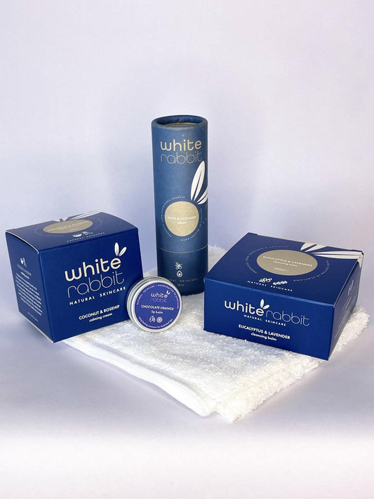 White Rabbit products including a box, can, and container on a white background