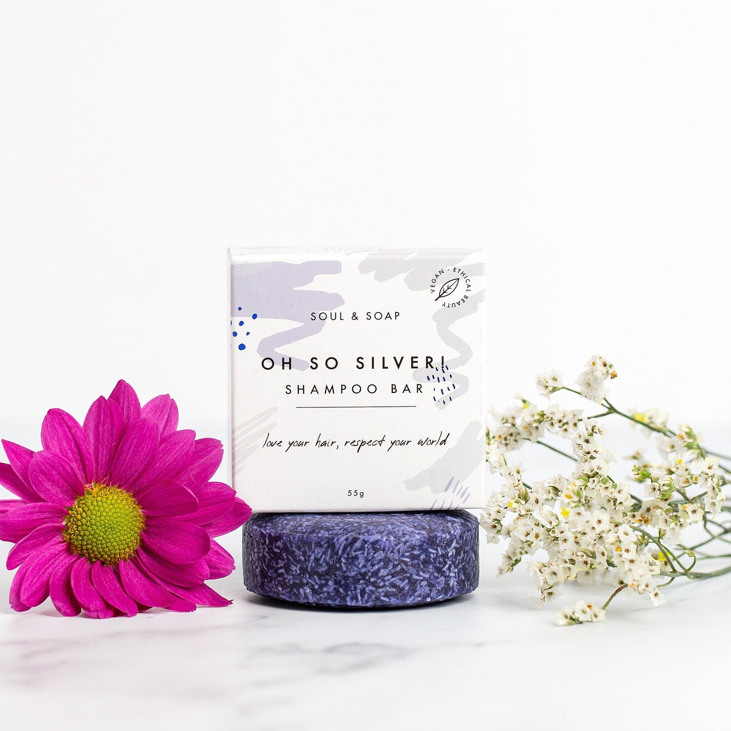 Shampoo bar with packaging and flowers on a white background