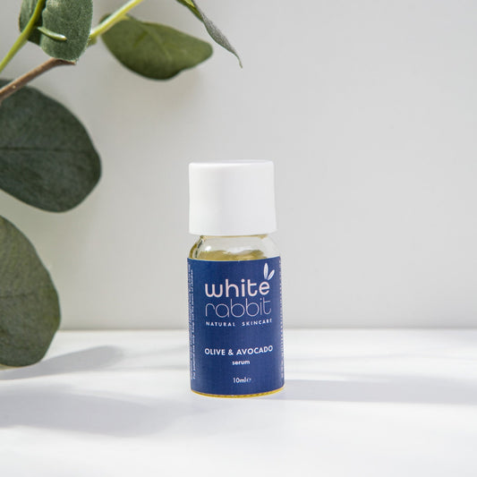 White Rabbit skincare serum bottle with a plant in the background