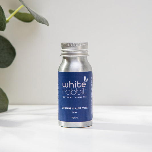 White Rabbit skincare bottle with blue label on a white surface