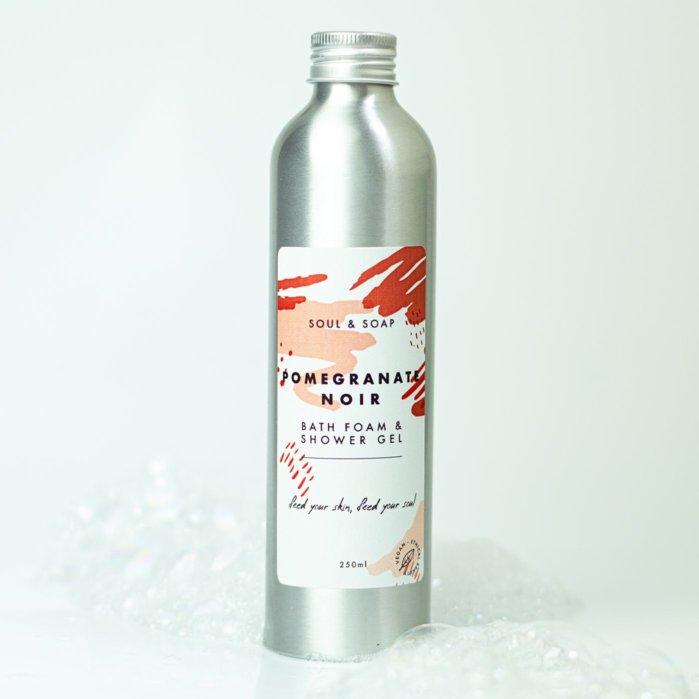 Silver bottle of 'Pomegranate Noir' bath foam and shower gel with a label on a white background.