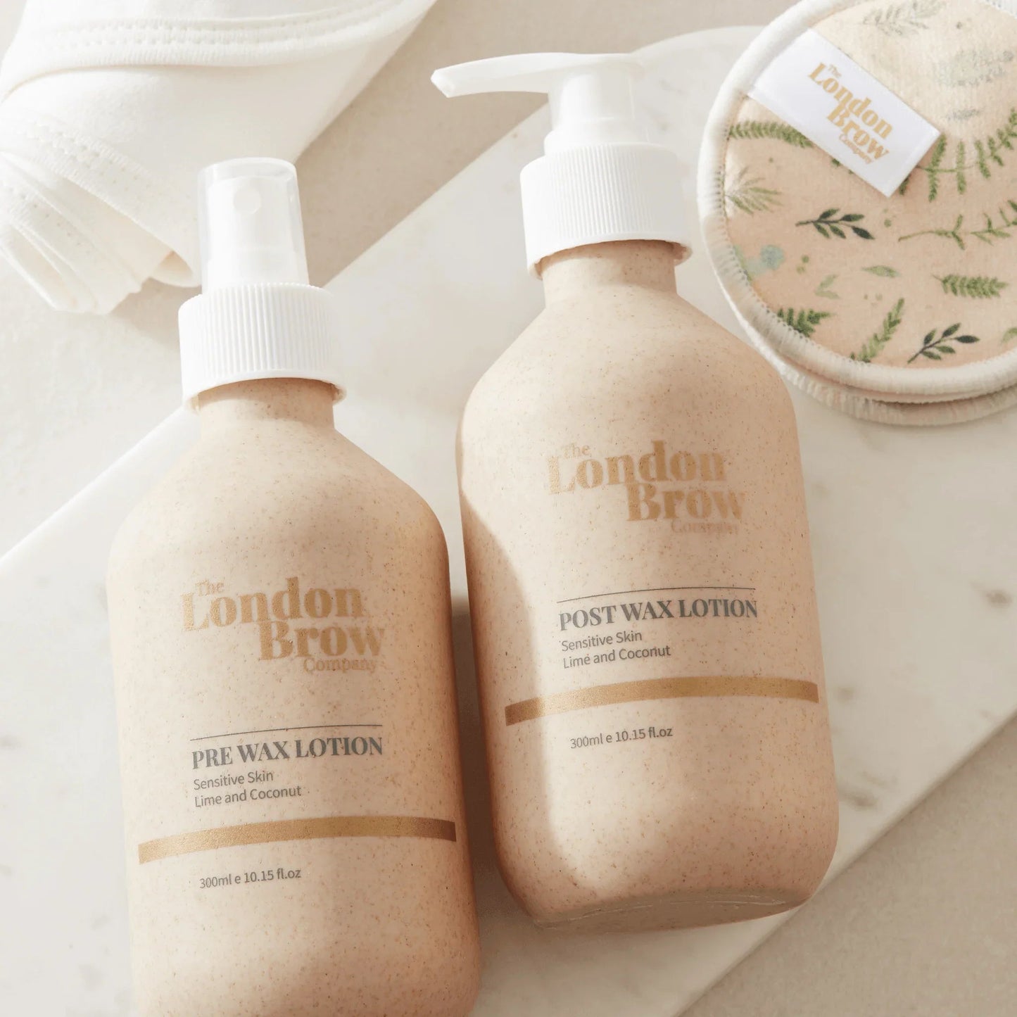 Two bottles of 'London Brow' skincare products on a neutral background