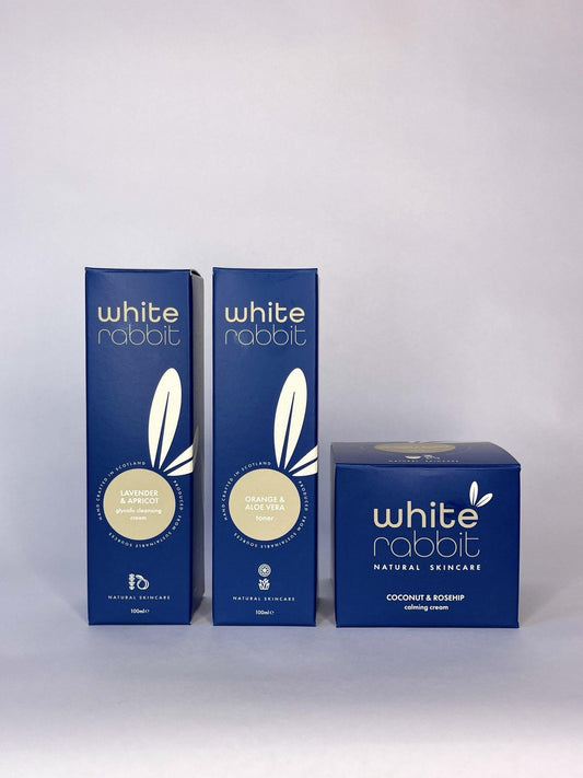 Three blue boxes of White Rabbit skincare products on a white background