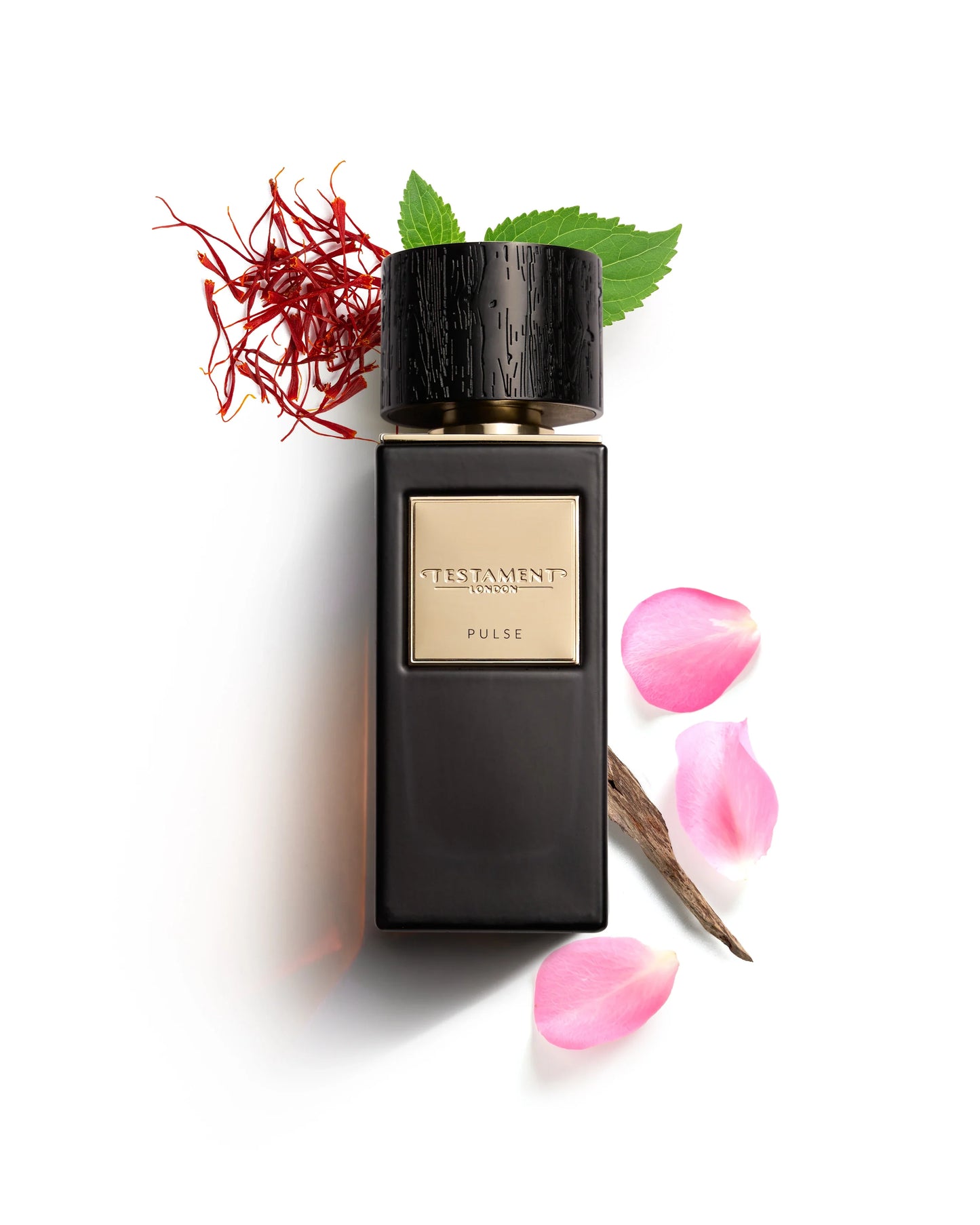 Perfume bottle with saffron, leaves, and pink petals on a white background