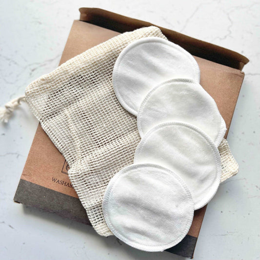 Set of reusable cotton pads with a mesh storage bag on a white surface